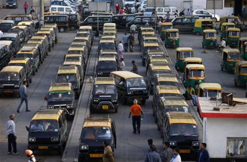 In this Monday, March 24, 2014 photo, traditional blackand-yellow licensed cabs stand parked waiting for customers at a railway station in New Delhi, India.
