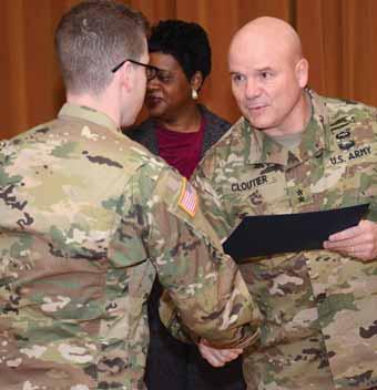 Center, Cloutier thanks a volunteer during a Helping Hands award celebration. Cloutier will relinquish command tomorrow to Brig. Gen. John P. Johnson in a ceremony at Victory Field.