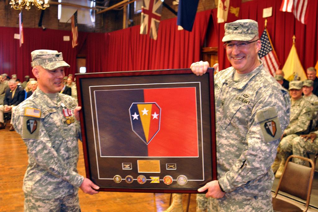 HIGHLIGHTS Col. Mark Piterski, left, outgoing commander of 50th Infantry Brigade Combat Team, New Jersey National Guard, receives a framed brigade flag from Col.