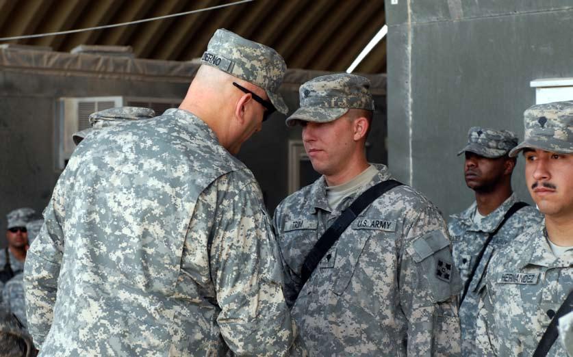 Around AO Warhorse Spc. Joshua Trim, E Co., 2nd Combined Arms Battalion, 8th Infantry Regiment, 2nd BCT, 4th Inf. Div., receives a coin of excellence from General Raymond T.