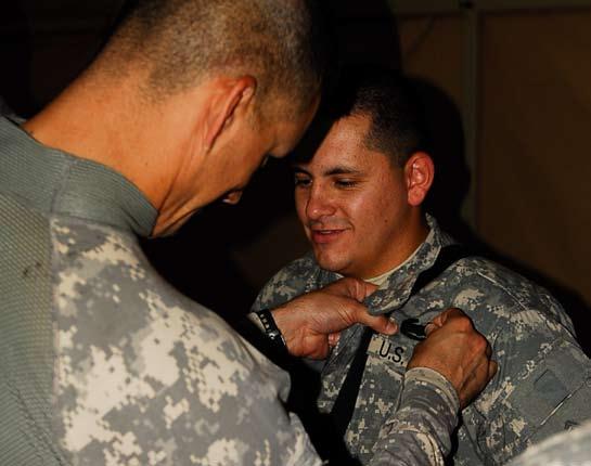 2nd Bn., 8th Inf. Regt. 8 Lt. Col. Doug Cardinale, commander, 2nd Bn., 8th Inf. Regt., 2nd BCT, 4th Inf. Div., pins the Combat Action Badge on Pfc. Matthew Campos, 2nd Bn., 8th Inf. Regt., during an award ceremony at Camp Wessam, May 23.