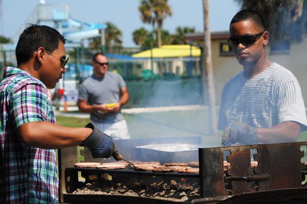 AS2(AW/SW) Jonilo Maglaya (left) and AD2(AW/SW) Carlos Garcia (right) cook hot dogs and hamburgers for nearly 200 Sailors and their families at the Fleet Readiness Center Southeast Detachment Mayport