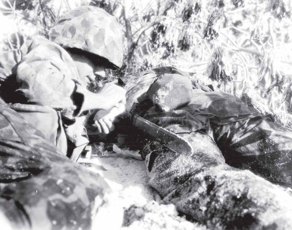 122 A hospital corpsman must keep his head low as he treats a wounded
