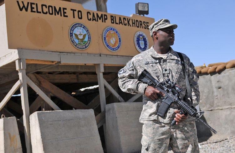 Spc. Robert Whitehead, of Purvis, Miss., a security guard for Headquarters Support Company of the 101st Airborne Division (Air Assault), stands guard near the entrance to Camp Black Horse on Oct.