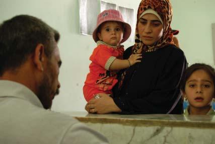 The brigade surgeon from the 37th Brigade, 9th Iraqi Army Division (Mechanized) talkes with a woman about her health problems at a Combined Medical Effort in Mushada, northwest of