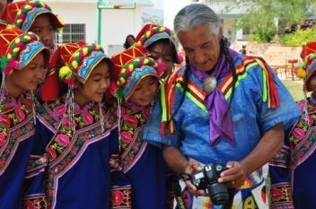 Lakota flute player, dancer, and storyteller, Kevin Locke, shares photographs with students at the Da Mai Di village in Kunming, China as part of a residency with Arts Midwest s Native American /