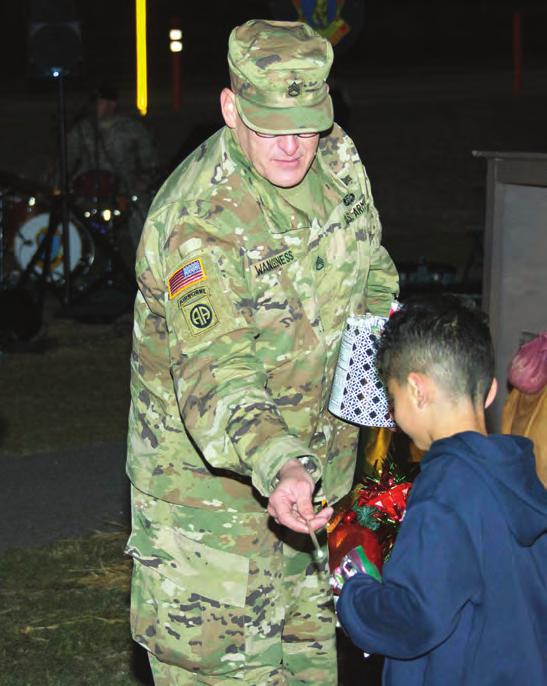 Scott Wangsness hands out gifts to children during Fort Jackson s 2016 Christmas Tree and Menorah Lighting celebration Dec. 9 near the Solomon Center on post.