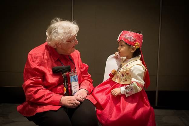 Margaret Evered, wife of Australian Veteran Alan Evered, is fascinated by the young girl and speaks with her after the