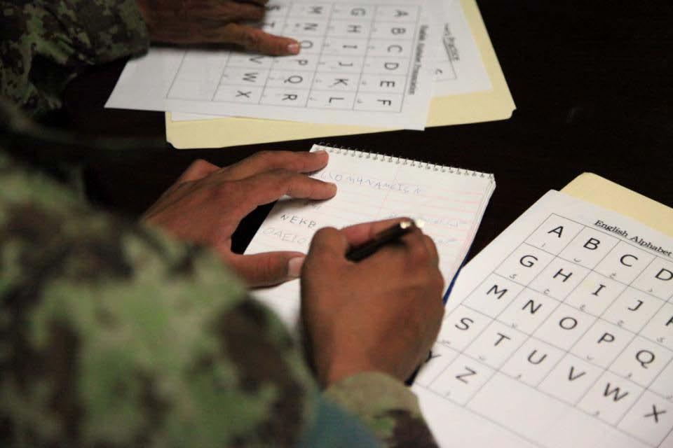 An Afghan National Army Soldier studies over his chart of English letters, at Combat Outpost Sayed