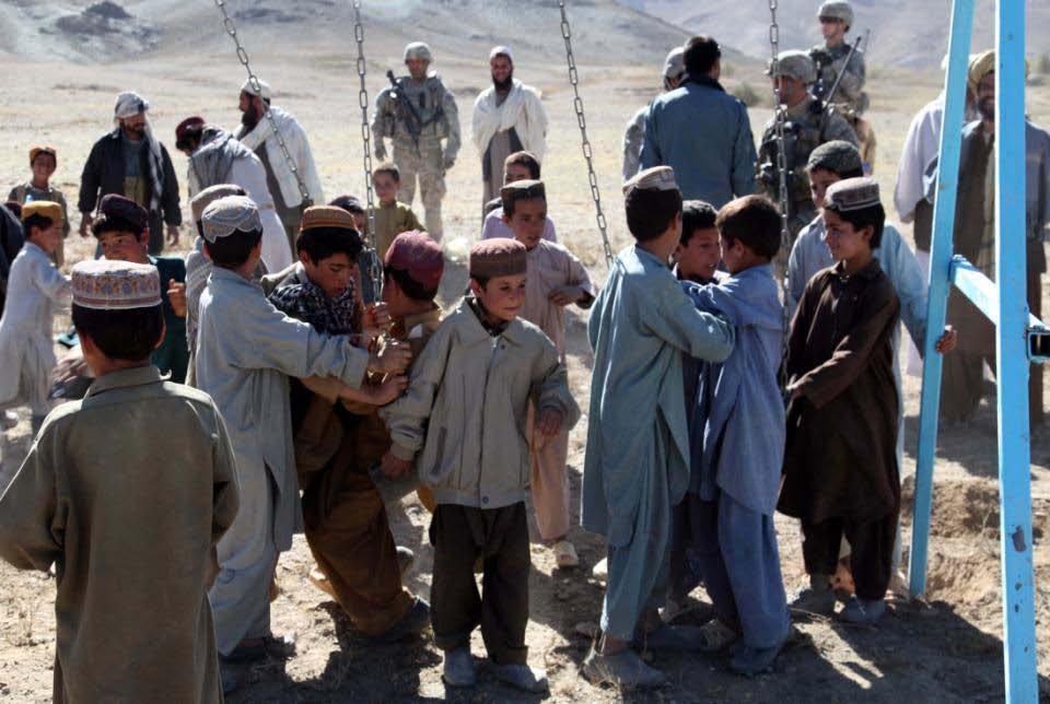 Afghan children from Pansh Pai village compete to get on a swing set built and delivered by the Afghan National Police and Soldiers of the 173rd Airborne Brigade Combat