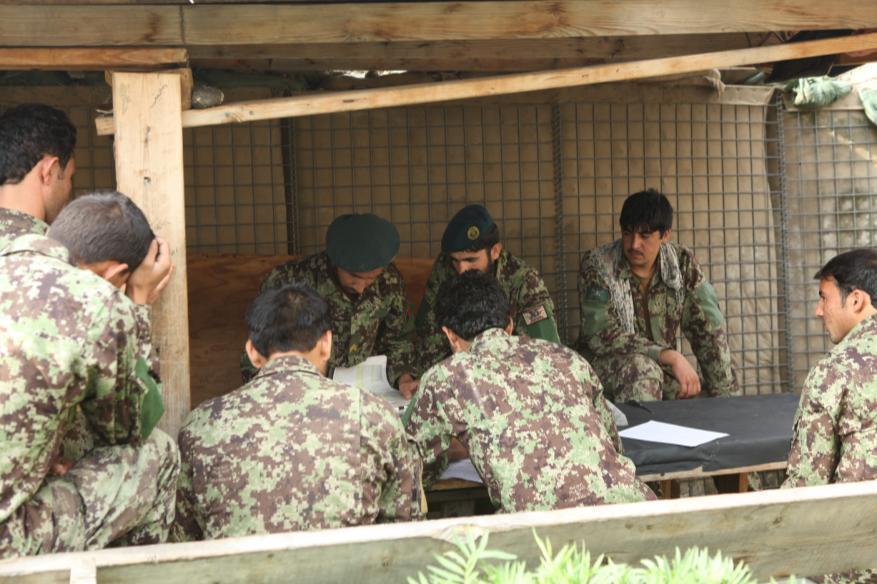 Soldiers with the Afghan National Army s 201st Corps, plot gird coordinates in preparation for a fire mission at Nangalam base, Kunar province, Afghanistan, Sept. 11, 2013.