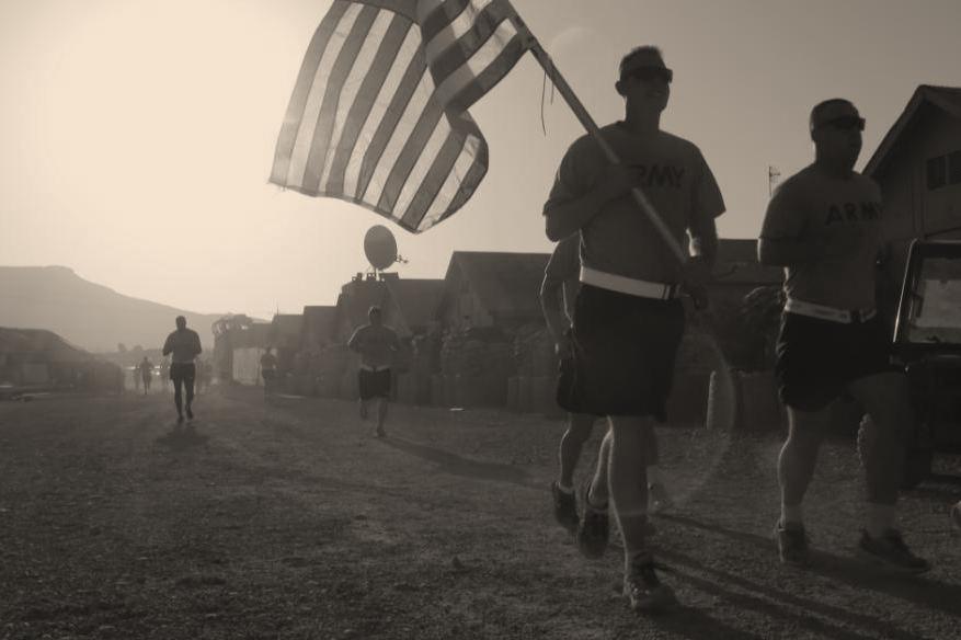 U.S. Army Soldier carries the American flag while running