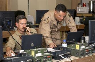 Lt. Col. Joseph Justice and Maj. David Wright, operation center directors from the 379th Air Expeditionary Wing, coordinate the flying schedule at an air operations center in Southwest Asia.
