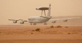 The massive job of coordinating the actions of thousands of strike, support, and cargo aircraft fell to the E-3 AWACS command and control aircraft. At right, an E-3 takes off during a sandstorm.