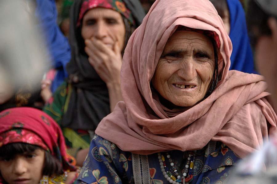 An elderly afghan woman from the Dudarek village waits for humanitarian aide during a hand out in