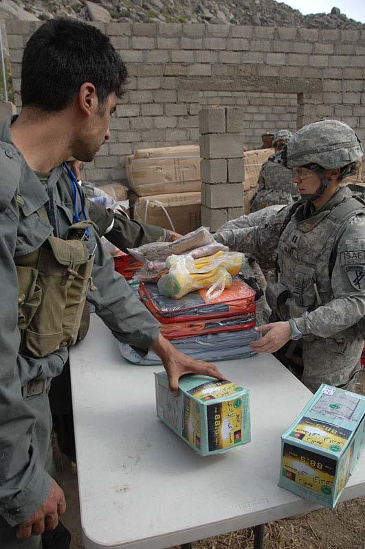 A member of the Afghanistan National Police hands U.S. Air Force Capt.