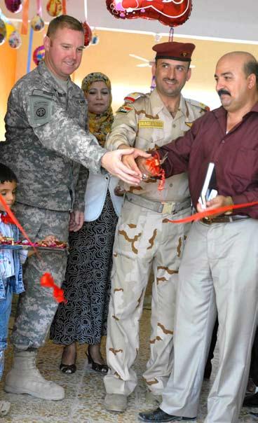 Nassir from the 42nd Brigade, 11th Iraqi Army Division, cut the ribbon together symbolizing the successful completion of the school s renovation June 25 in Adhamiyah, northern Baghdad. By Sgt.