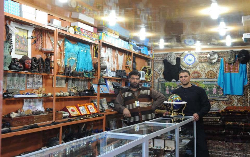 Sherbaba (On the left) and Zia KPZ (On the Right), Afghan business owners, stand behind the glass counter of their business at the Bazaar on Forward