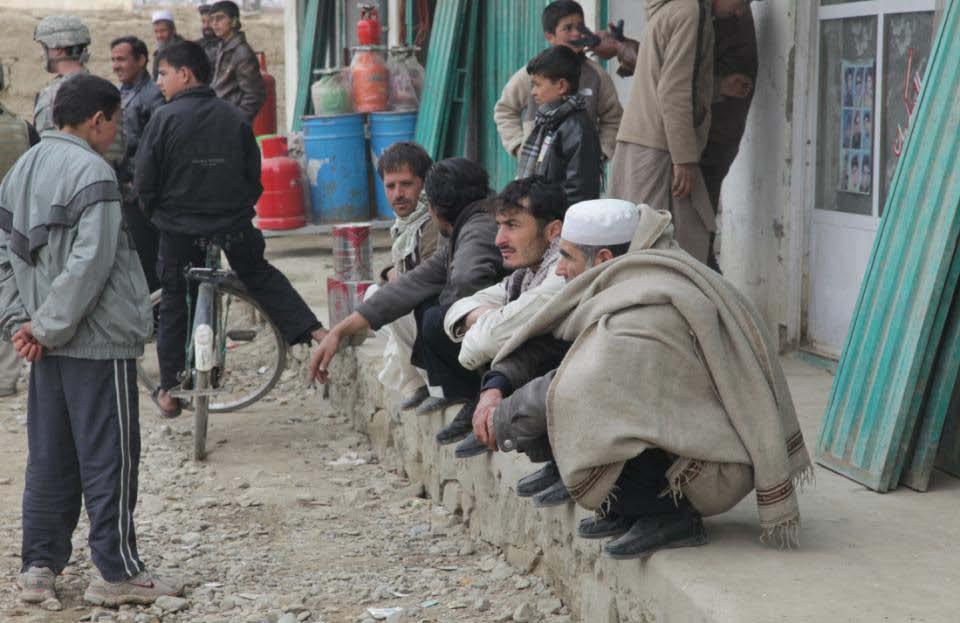 Local nationals observe the happenings at the bazaar in a village near Bagram Airfield, Parwan