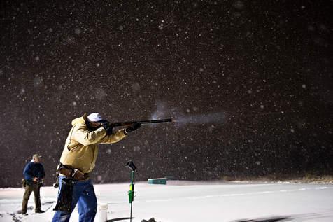 Brian Powers~Sun-Times Media Jim Monk, of Naperville, fires a shot in the snow at Naperville Sportsman's Club as Jim Chakour, back, of Naperville, waits for his turn on Thursday, January 12,