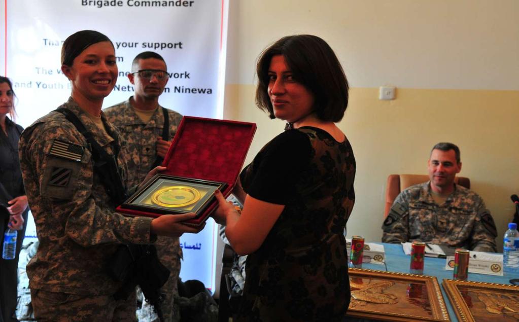 U.S. Army 2nd Lt. Kassandra Williams attached to the Ninewa Provincial Reconstruction Team is presented with an award from the Ninewa Province Women's Association in Qaraqosh, Iraq, October 10, 2010.