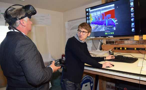 Henry Trudel (left) hospital facilities manager, uses VR Goggles to review a 3-D model of the utilities placed on the roof of the new addition, while Jonathan Savosnick, of DPR Construction, operates