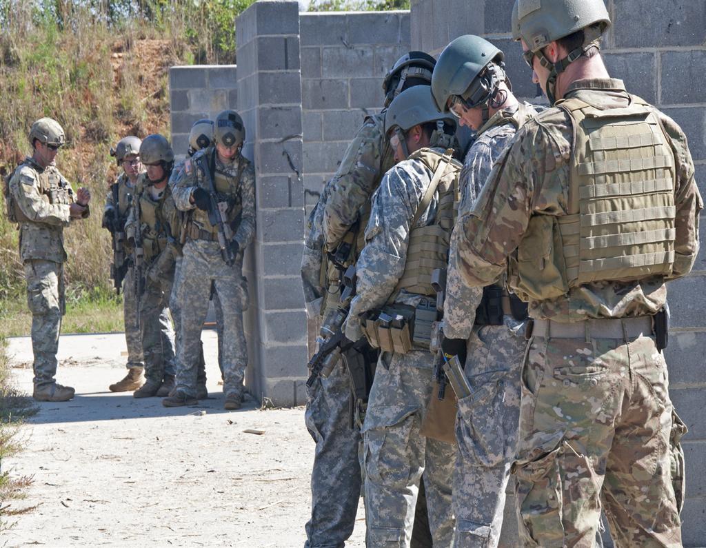 Alabama Guardsman 5 Brenda Thomas/photo Members of the 20th Special Forces Group (Airborne) take cover behind cinder block barriers near a door
