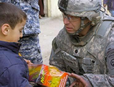 , commander of the 2nd Battalion, 505th Parachute Infantry Regiment, 3rd Brigade Combat Team, 82nd Airborne Division, gives an Iraqi boy a toy during a school supply distribution event Feb.