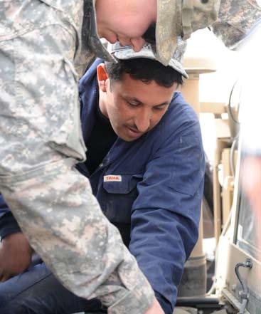 , 505th Parachute Infantry Regiment, 82nd Airborne Division, shows an National Police mechanic the location of components under the hood of an up-armored humvee during a maintenance training event