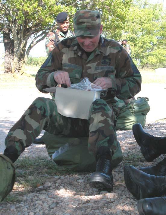 ATSO TRAINING On-final Staff Sgt. Derek Wilson checks his chem gear before the training began. Master Sgt. Robert Enriquez uses a lull in the attacks to quiz participants on proper wear of the helmet.
