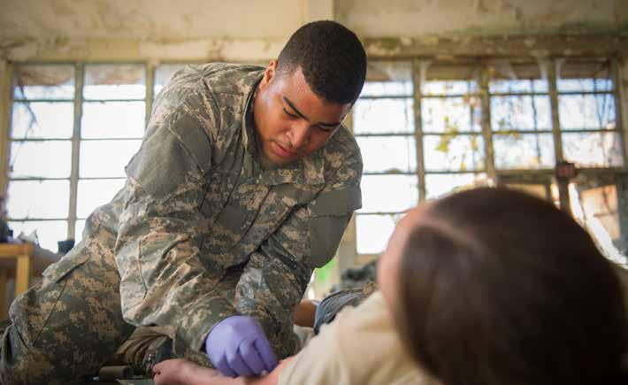 Spc. William Manley, a combat medic from the Walter Reed National Military Medical Center, prepares to give Spc.