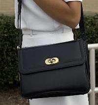 Description: The handbag must be of plain black, brown or white grain leather or synthetic leather, rectangular in shape and designed with a flap.