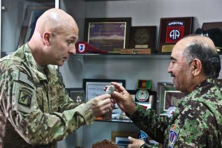 Afghan National Army Maj. Gen. Mohammad Yaftali, commander of the 203rd Corps, shows U.S. Army Lt. Gen. Joseph Anderson, commander of the 18th Airborne Corps, the coins on display in his office at Forward Operating Base Thunder, Paktia province, Afghanistan, March 5, 2014.