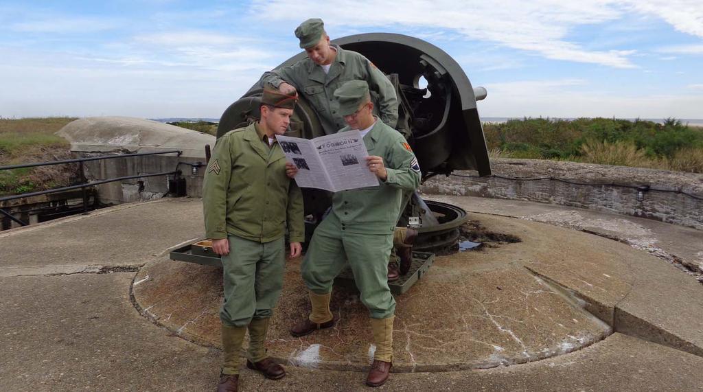 Below SGT Egan, PVT Budjos and SSG Minton read the 14 October 1943 edition of the