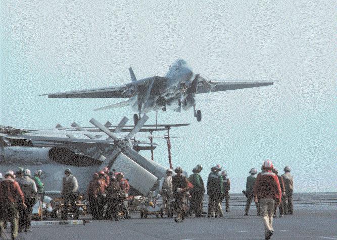 PHAN Lindsay Switzer At sea on board George Washington (CVN 73) during Operation Enduring Freedom: above, a VF-103 Tomcat comes in for a landing on the busy flight deck.