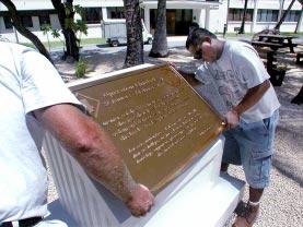 (See last Friday s Hourglass for details about the memorials.) Above: Darin Haaversen polishes the plaque honoring the lost Makin Raiders Friday morning.
