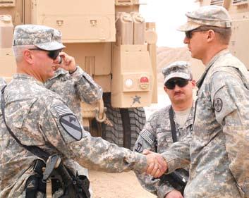 , receives a coin from 1st Cavalry Division s Command Sgt. Maj. Rory Malloy, of Campbellsburg, Ind., for combat excellence, Oct. 22.