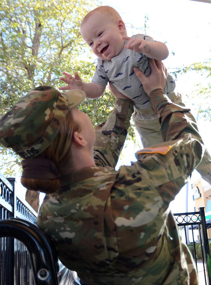 Spc. Christina Shields of Headquarters and Headquarters Company, 47th Brigade Support Battalion, 2nd Brigade, 1st Armored Division, plays with her 10-month-old, John Henry Jr.