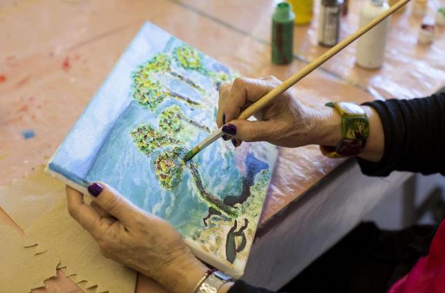 Olinda Marti-Volkoff, a Medicare recipient, works on a painting while taking a class at the On Lok 30th Street Senior Center in San Francisco, Calif., on Friday, December 2, 2016.