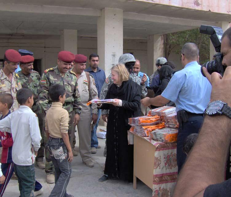HUMAN INTEREST A Provincial Reconstruction Team member hands out school supplies to local children Courtesy Photo Shortly after the fall of the Hussein regime and before the new democratic government