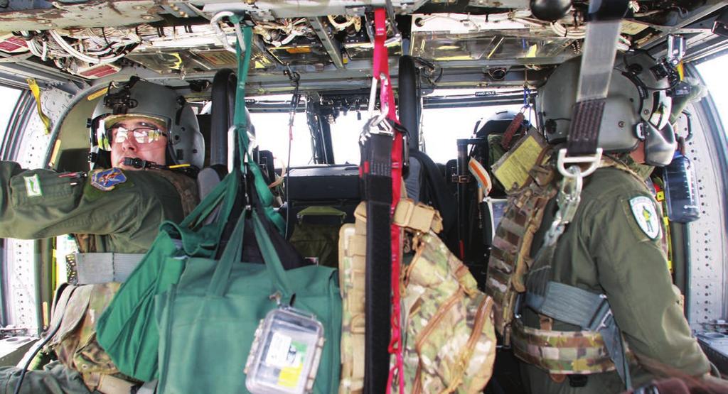 1 2 1 Bossy (left) and Vega Guilbe sit in the back of a Pave Hawk.