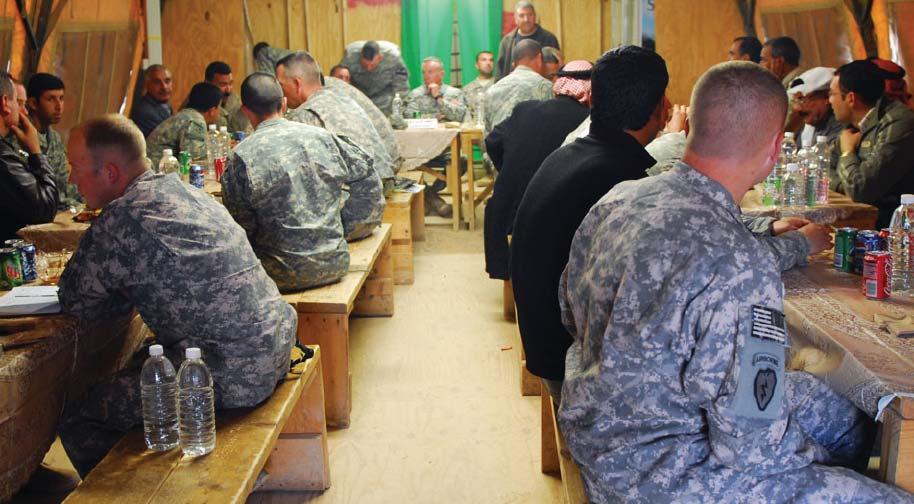 The leaders of 1st Brigade Combat Team, 1st Armored Division, and 2nd Brigade Combat Team, 1st Calvary Division, share dinner with leaders from the Sons of Iraq at Joint Security Station McHenry in
