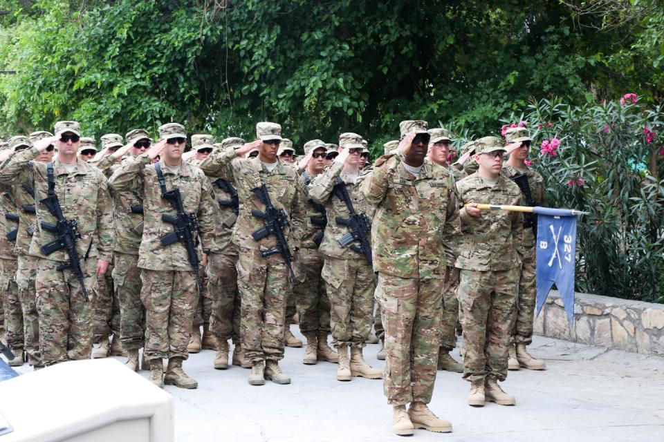 U.S. Soldiers of Bravo Company, 1st Battalion, 327th Infantry Regiment, 1st Brigade Combat Team, 101st Airborne Division, salute the flag while the national anthem plays during a change of command