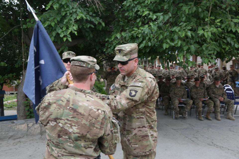 U.S. Army Lt. Col. Stephen Shrader, commander of 1st Battalion, 327th Infantry Regiment,1st Brigade Combat Team, 101st Airborne Division, passes the guidon to Cpt.