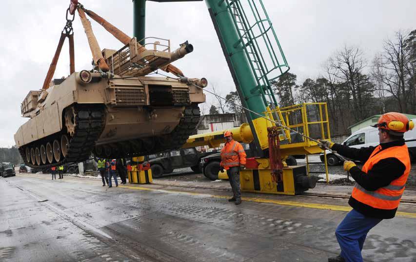 German railway loadmasters with the Theater Logistics Support Center Europe help load an Abrams main battle tank at the railhead in Kaiserslautern.