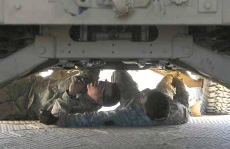 FEATURES Army mechanics work on the underbelly of a humvee in the maintenance tent of the 542nd Support Maintenance Company on Feb. 18, 2016, at Fort Polk, Louisiana. (Photo by Sgt.