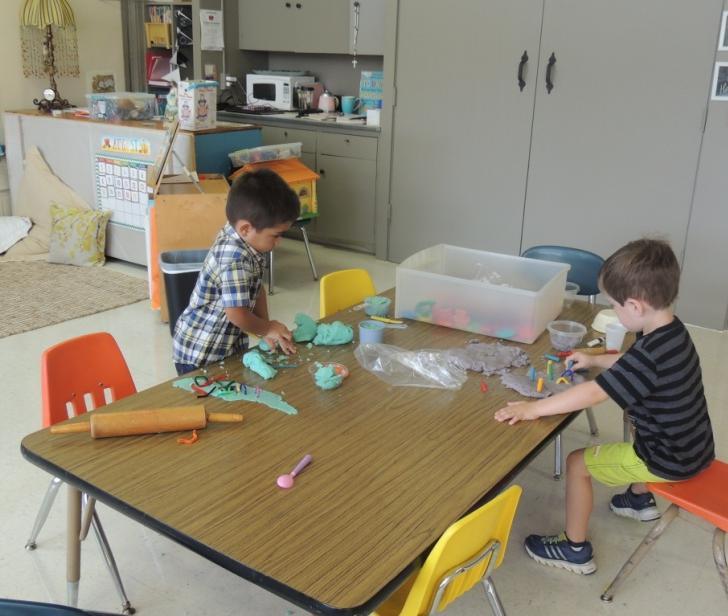 Preschool students playing with clay. Ms.