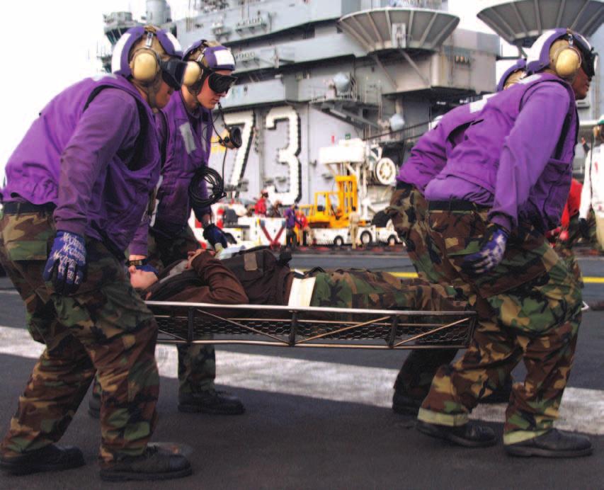 Fuel Handlers simulate carrying a wounded shipmate during a Mass Casualty drill aboard the Nimitz-class aircraft carrier USS George Washington (CVN 73).