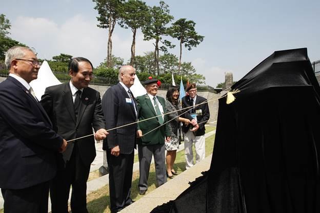 Shown removing veil from Canadian memorial that is situated in the Sunken Gardens at the Korean War Memorial in Seoul are (left) Lieutenant General (Retired) Sun Young-jae, Director