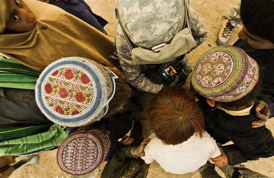 U.S. Air Force Staff Sgt. Christine Jones, a photographer with the 4th Combat Camera Squadron, shares her photographs with Afghan children in Shabila Kalan Village, Zabul Province, Afghanistan, Nov.